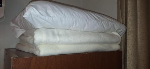 a stack of white towels sitting on a shelf at ANDINO HOTEL MACHUPICCHu in Machu Picchu