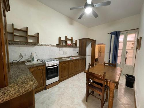 uma cozinha com uma mesa e uma ventoinha de tecto em Beach House - Seaview Holiday Home em Marsalforn