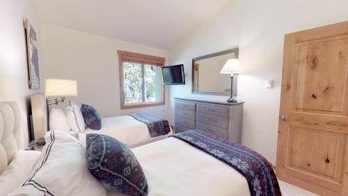 a bedroom with two beds and a mirror at Terracehouse - CoralTree Residence Collection in Snowmass Village