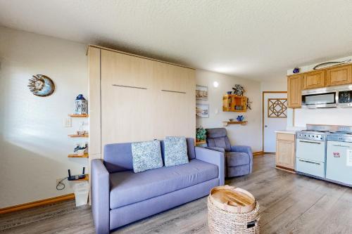 a living room with a purple couch and a kitchen at Little Slice of Heaven in Neskowin