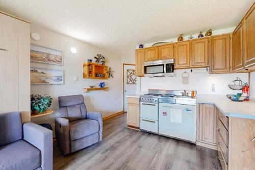 a kitchen with wooden cabinets and a chair in a room at Little Slice of Heaven in Neskowin