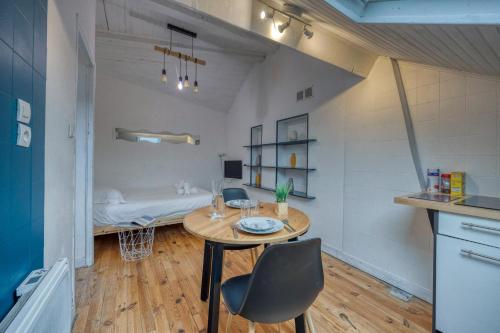 une pièce avec une table, des chaises et un lit dans l'établissement Le Jean Jaurès - Gare de Grenoble / Calme, à Fontaine
