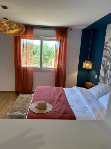 a bedroom with a bed with a hat on it at La poudrière in Figari