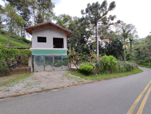 une maison avec un garage au bord d'une route dans l'établissement Canto das primaveras, à Santo Antônio do Pinhal