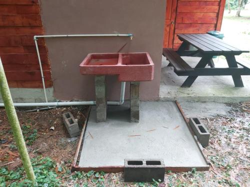 a red sink sitting next to a picnic table at Into the Greens in Madre de Dios