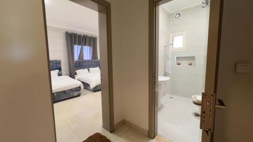 um quarto com uma cama e uma casa de banho com um espelho. em أنين الحالمه em Durat Alarous