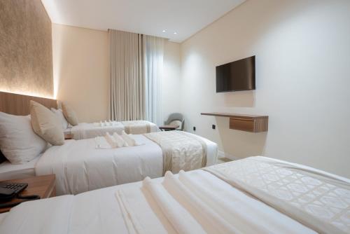 a hotel room with two beds and a television at Rawha Al Maqam Ajyad Hotel in Makkah