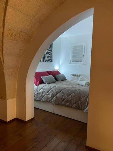 Schlafzimmer mit einem Bett in Bogenrichtung in der Unterkunft Sweet Aura in Brindisi