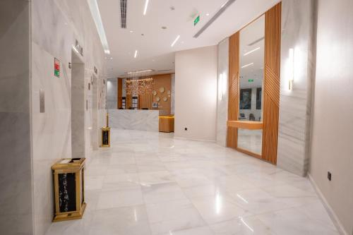 a hallway with a large white tile floor and a room at Rawha Al Maqam Ajyad Hotel in Makkah