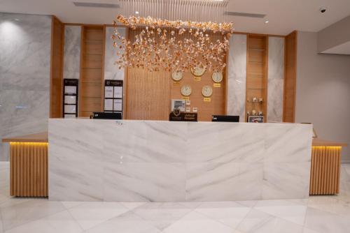 a lobby with a large white counter in a room at Rawha Al Maqam Ajyad Hotel in Makkah