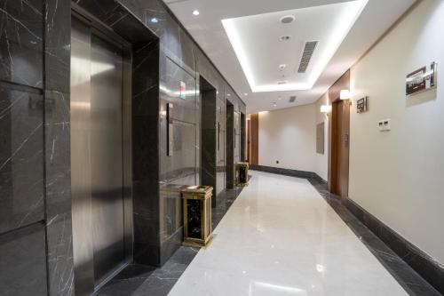 a hallway of a building with a shiny metal wall at Rawha Al Maqam Ajyad Hotel in Makkah