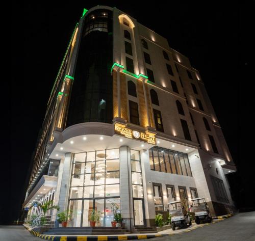 فندق روحة المقام في Ajyad: مبنى طويل مع واجهة مضاءة في الليل