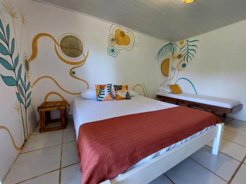 a bedroom with a bed with a red blanket at Espaço Circular in Itacaré