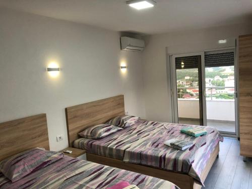 1 dormitorio con 2 camas y balcón en Home REX, en Ulcinj