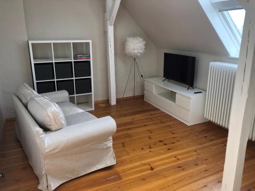 ein Wohnzimmer mit einem weißen Sofa und einem TV in der Unterkunft Ferienhaus ON90 in Wilhelmshaven