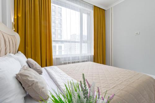 1 dormitorio con 1 cama y una ventana con cortinas amarillas en Apart Astana, Sat City возле Хан-Шатыра en Astaná