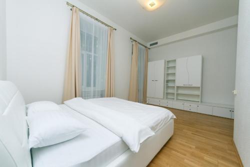 Майдан провулок Музейний 8-Б في كييف: غرفة نوم بيضاء مع سرير أبيض ونافذة