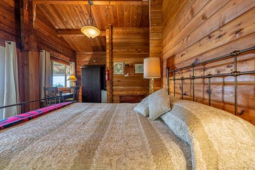 a bedroom with a bed in a room with wooden walls at Alert Bay Lodge in Alert Bay