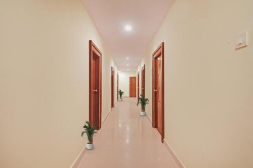 um corredor com portas e vasos de plantas num edifício em Townhouse Hotel Ragas Grand em Hyderabad