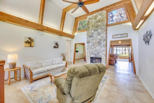 a living room with a couch and a stone fireplace at Unique Melrose Home with Private Dock and Lake Access! in Keystone Heights