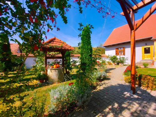 a house with a garden with a gazebo at Pensiunea Keisd in Saschiz