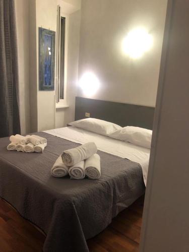 um quarto com uma cama com toalhas em ALMA Rooms Appia em Roma
