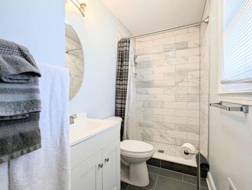 a white bathroom with a toilet and a sink at Spacious family friendly home with game room by UNC Charlotte in Charlotte
