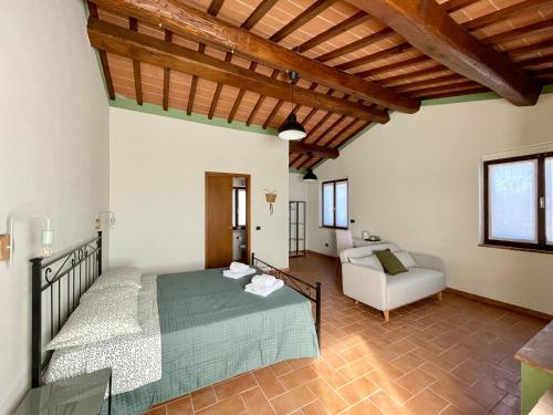 sypialnia z łóżkiem i kanapą w pokoju w obiekcie Casale dell'Assiolo - Affittacamere w mieście Castiglione del Lago