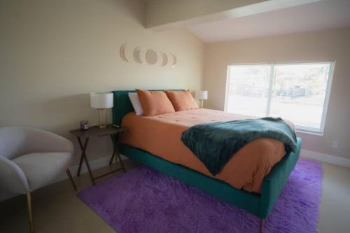 a bedroom with a bed with a purple rug and a window at 15Min from FLL airport W 8ft pool & NEW hot tub! in Sunrise