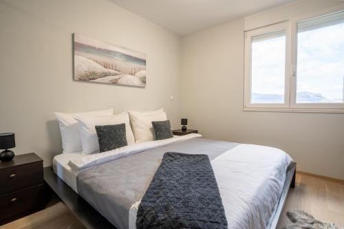 sypialnia z dużym łóżkiem z białą pościelą i poduszkami w obiekcie Apartman Aricibald w Splicie