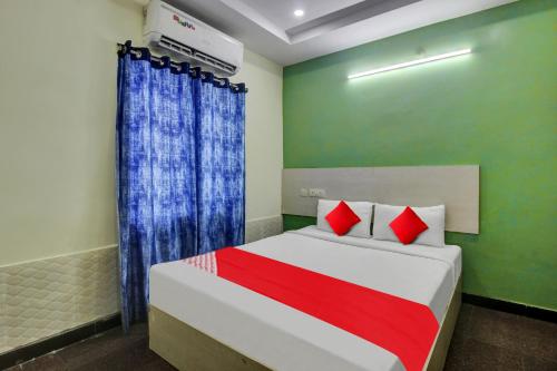 1 dormitorio con 1 cama con cortinas rojas y azules en Flagship Hotel Lavish Stay, en Surūrnagar