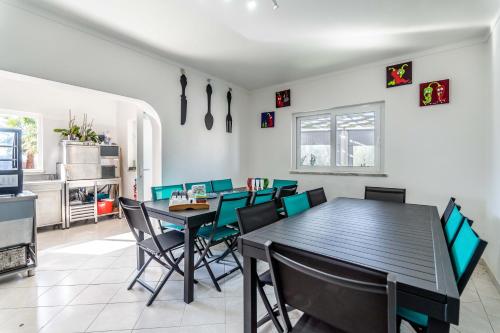 una sala da pranzo con tavolo e sedie di Villa Paradis Pêra - Casa completa para férias a Pêra