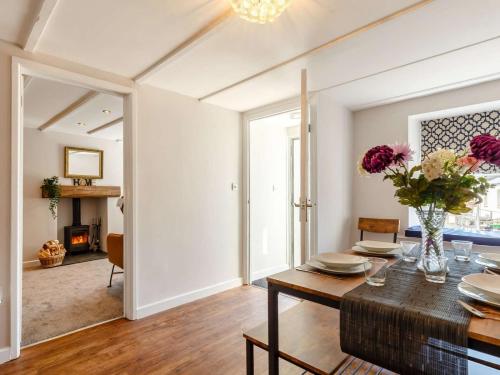 a dining room with a table and a fireplace at Bells Cottage - 5 min walking distance to train station and town on your doorsteps in St Austell