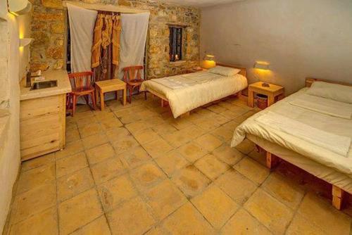 a bedroom with two beds and two chairs in it at Dana Hotel in Tufailah