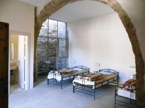 2 Betten in einem Zimmer mit einem großen Fenster in der Unterkunft Dana Hotel in Tufailah