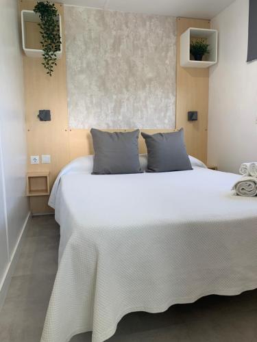 a bedroom with a large white bed with gray pillows at PALMAR A Tres Minutos Andando De La Playa NO GRUPOS in El Palmar