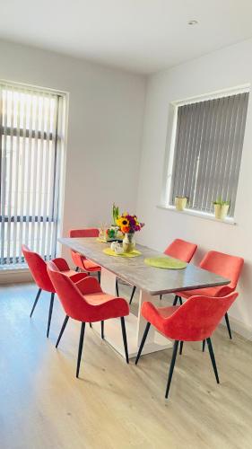 a dining room with a table and red chairs at Shadwell - walking distance to Tower Bridge, two stations in close proximity in London