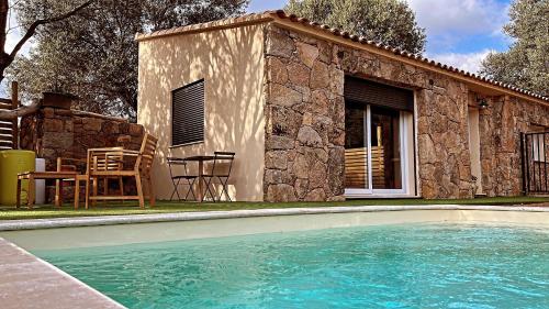 a house with a swimming pool in front of a building at Chez François et Cécile in Figari