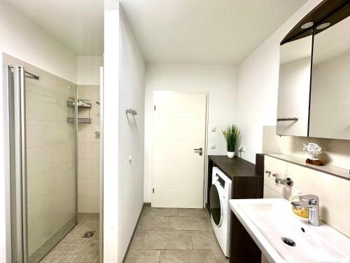 a white bathroom with a sink and a shower at Haus Sterntaucher Appartement 4 in Thiessow
