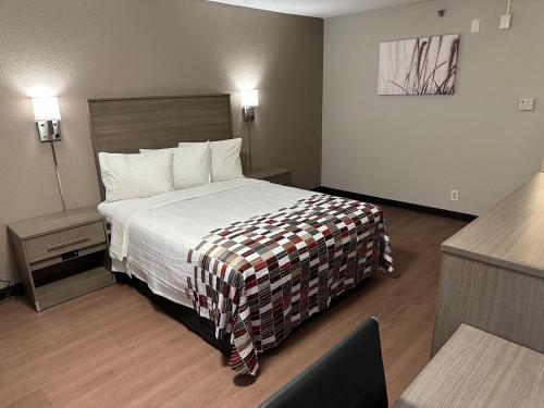 a hotel room with a large bed in a room at Red Roof Inn Auburn Hills in Auburn Hills