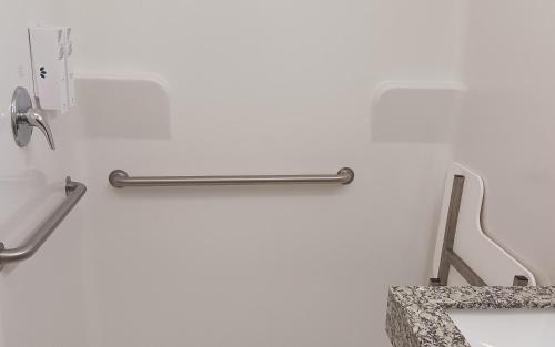 a white wall with a metal towel rack on it at Red Roof Inn Baton Rouge in Baton Rouge