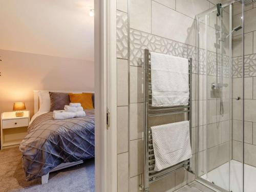 a bedroom with a bed and a glass shower at Bells Cottage - 5 min walking distance to train station and town on your doorsteps in St Austell