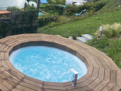a large pool of blue water in a wooden enclosure at Glamping La Cepa GUATAPÉ in Guatapé
