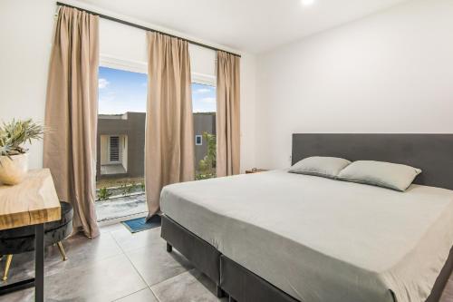 a bedroom with a large bed and a large window at Modern 3-Bed Apartment in Papaya Resort in Grote Berg