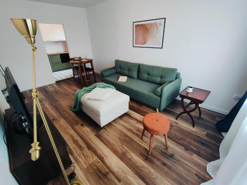 ein Wohnzimmer mit einem grünen Sofa und einem Tisch in der Unterkunft Apartament Inka in Goleniów