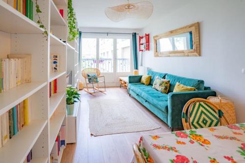 - un salon avec un canapé bleu et des étagères dans l'établissement Jolie nid familiale, à Paris