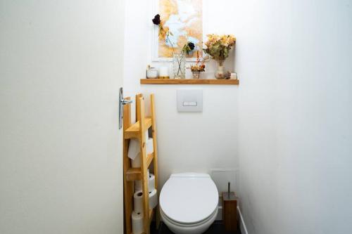 une salle de bain avec des toilettes blanches dans une chambre dans l'établissement Jolie nid familiale, à Paris
