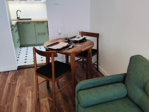 uma mesa de jantar com uma cadeira e um sofá em Apartament Inka em Goleniów