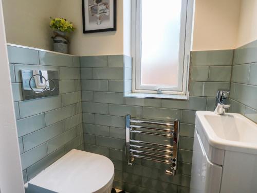 ein Bad mit einem WC, einem Waschbecken und einem Fenster in der Unterkunft The Chocolate Box in Weymouth
