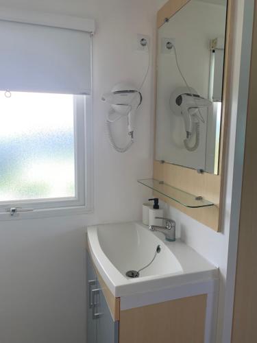 a bathroom with a sink and a mirror and a window at PALMAR A Tres Minutos Andando De La Playa NO GRUPOS in El Palmar